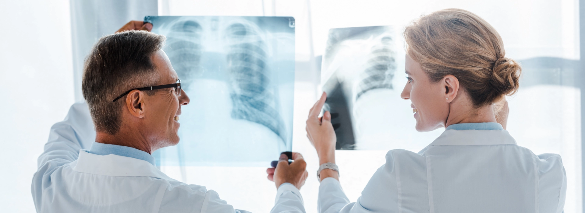 Zwei Ärzte analysieren gemeinsam Röntgenbilder der Lunge in einer Klinik – attraktive Ärztestellen für Fachärzt