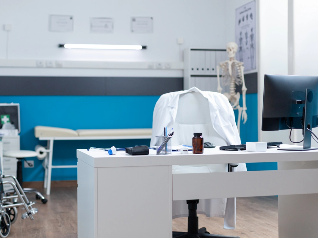 Moderner Untersuchungsraum in einer Arztpraxis mit Schreibtisch, Computer und Behandlungsbank – Praxisvertretung und Stellenangebote für Ärzte